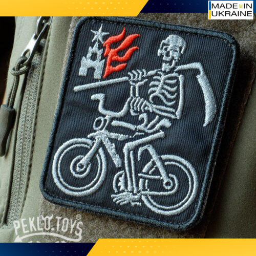 Patch. A Skeleton on a bicycle. kremlin is on fire. War in Ukraine