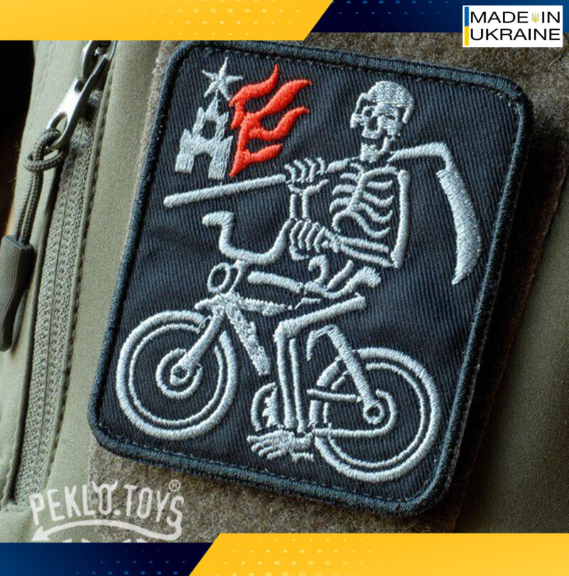 Patch. A Skeleton on a bicycle. kremlin is on fire. War in Ukraine
